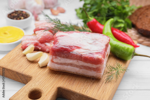 Fototapeta Naklejka Na Ścianę i Meble -  Pieces of tasty pork fatback with garlic and chilli pepper on white table