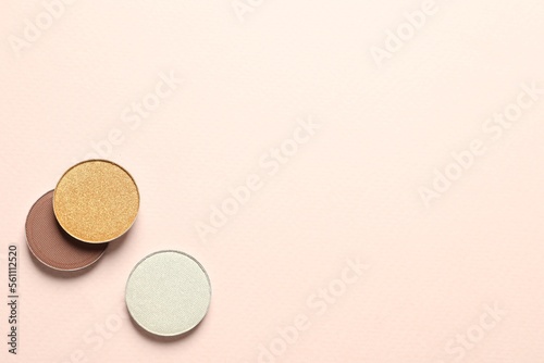 Different beautiful eye shadows on beige background, flat lay. Space for text