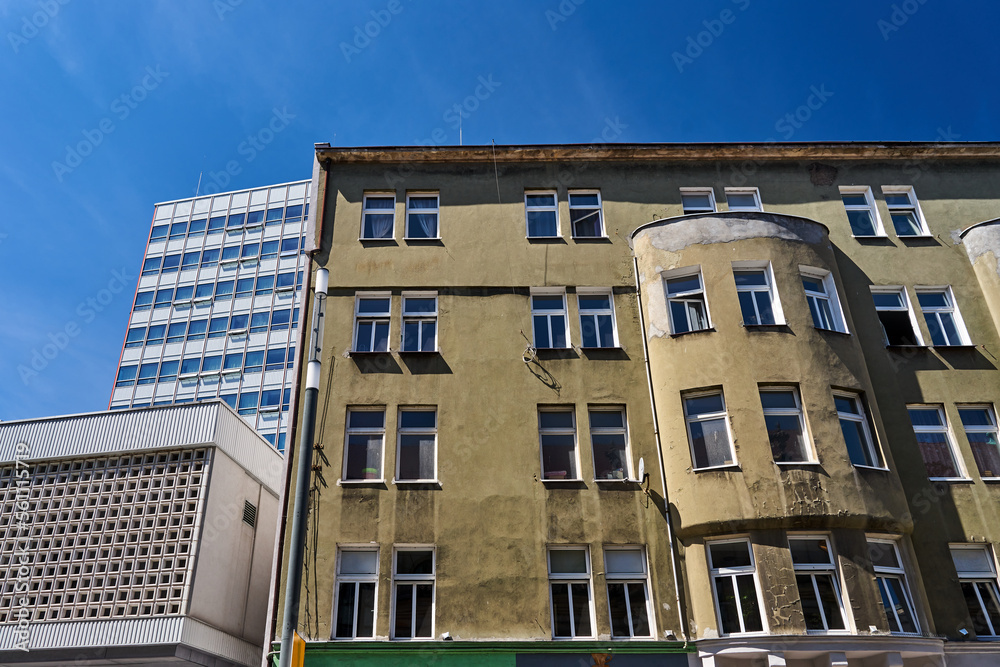 Fototapeta premium the facade of a historic tenement house and a fragment of a modern office building in the city of Poznan