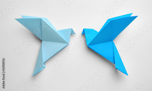 Origami art. Colorful handmade paper birds on white background, flat lay
