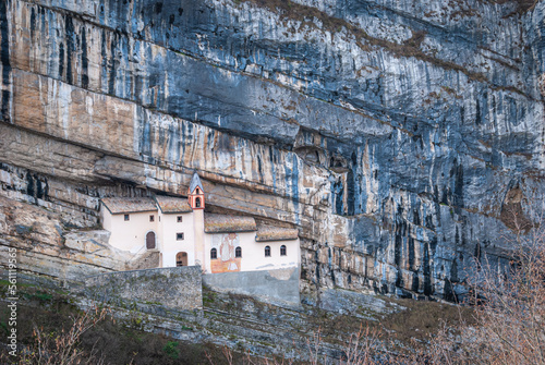 Fototapeta Eremo di San Colombano is a hermitage in Trambileno, Italy, notable for its location in the side of a mountain
