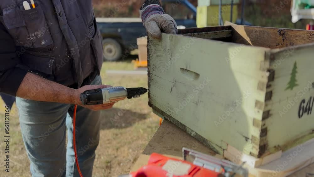 Old Wooden Beehive Restoration, Worker Using Nail Gun On Wood Old Wooden Beehive Restoration, Worker Using Nail Gun On Wood
