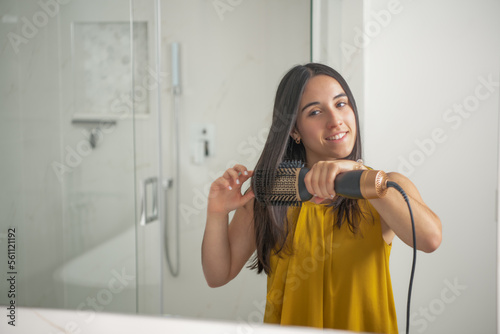 Teen using a hair dryer brush