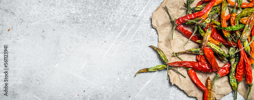 Dried hot pepper pods on paper.