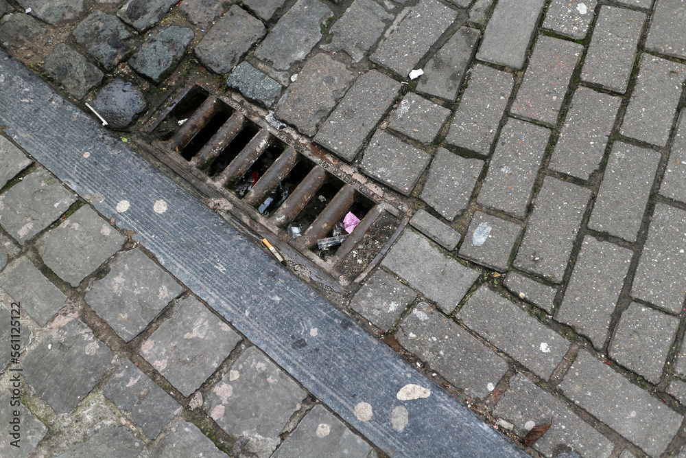 Cobbled street with cigarette butts and drain - Brussels - Belgium