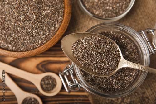 Chia seeds in bowl and spoons on brown wood texture. Diet food. Superfood. Healthy food. Space for text, copy space