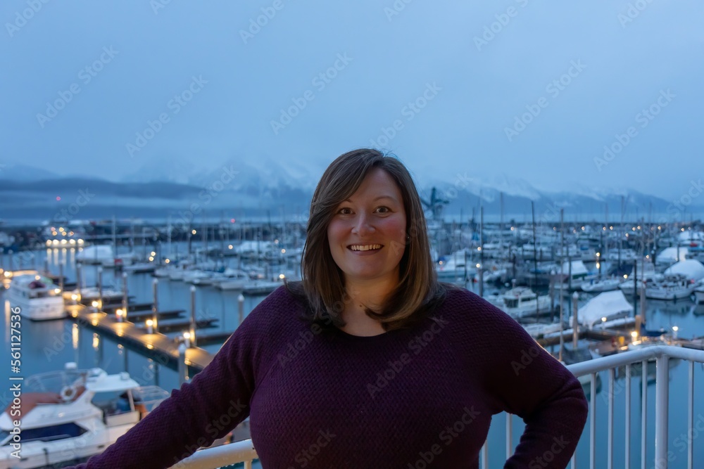 lady standing on balcony in front of Seward Harbor in Seward, Alaska in winter