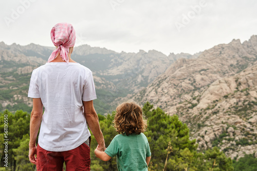 A Woman with pink scarf against breast cancer in nature with her son