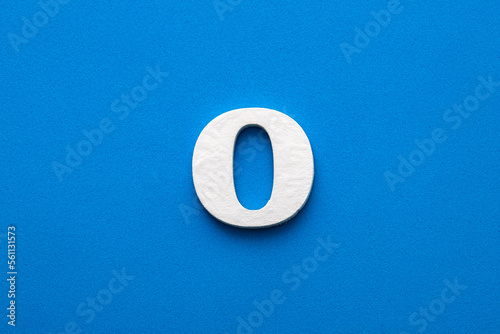 Alphabet letter O - White wooden letter on blue foamy background