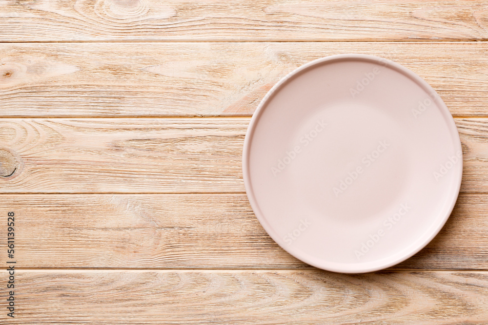 Top view of empty light plate on wooden background. Empty space for your design