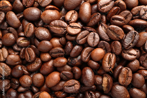 Close-up macro shot of the coffee beans lying on a flat surface. The photo shows the fine details and the texture of the product and can be used as a background.