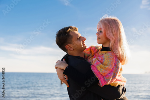 Happy couple hugging on the seashore at sunset of the day. Walk near the sea. Romantic time. Happy young people. Valentines day