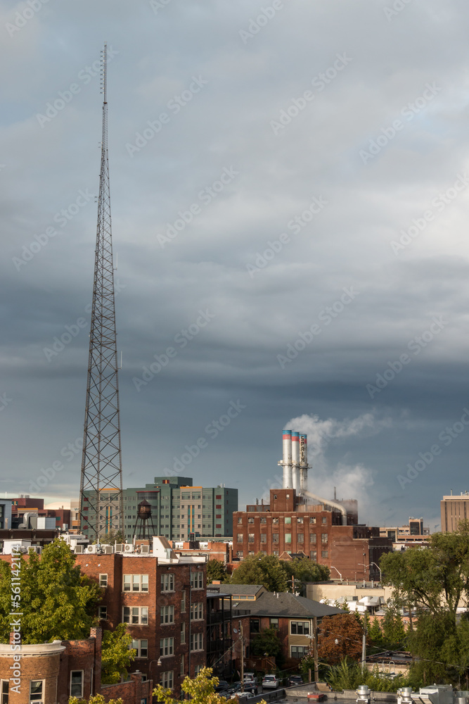 View of Detroit Thermal steam energy utility, historic Willis Avenue Station in Midtown Detroit, Michigan and steam rising from the stacks, as well as a large radio tower antennae.