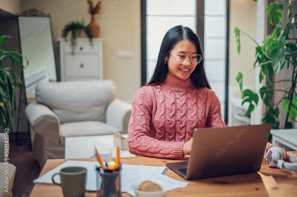 Vietnamese Asian woman using laptop while working at home Vietnamese Asian woman using laptop while working at home