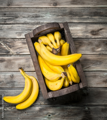 Lots of bananas in a black wooden box.