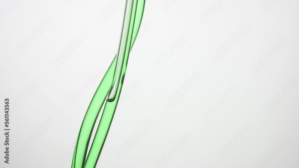 Macro shot of hemp oil is flowing down in two transparent lab connecting tubes on grey background | Abstract face care products with essential oils formulating concept Macro shot of hemp oil is flowing down in two transparent lab connecting tubes on grey background | Abstract face care products with essential oils formulating concept