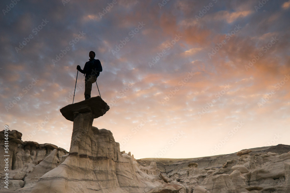 A man hiking and exploring the complex sandstone rock formations at Bisti Badlands outside of Farmington, New Mexico. A man hiking and exploring the complex sandstone rock formations at Bisti Badlands outside of Farmington, New Mexico.