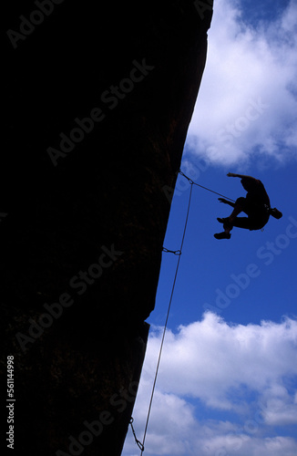 A male rock climber falls while ead climbing. photo