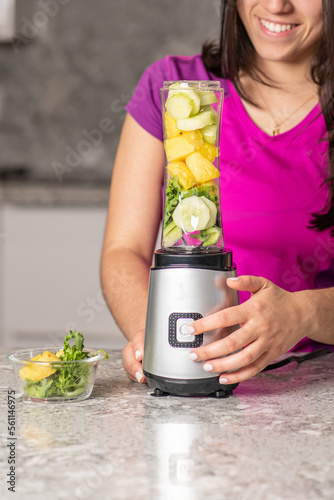 latin teen preparing a smoothie on a kitchen