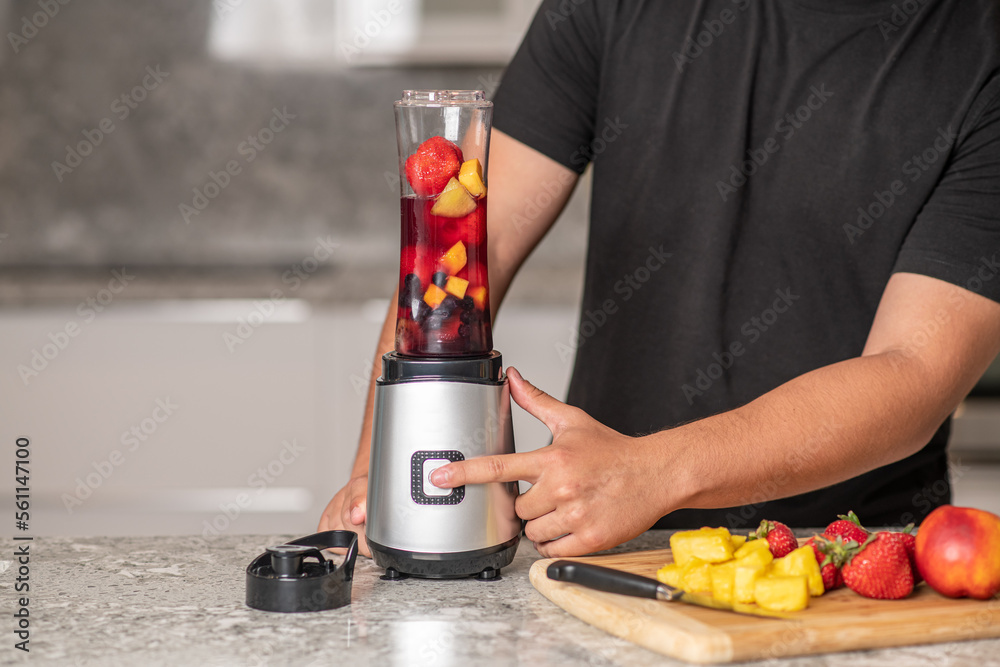 hispanic teenager preparing a smoothie on a blender