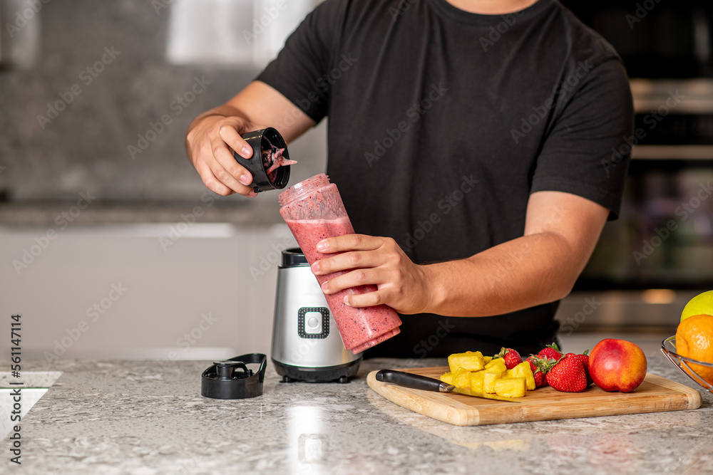 hispanic teenager preparing a smoothie on a blender