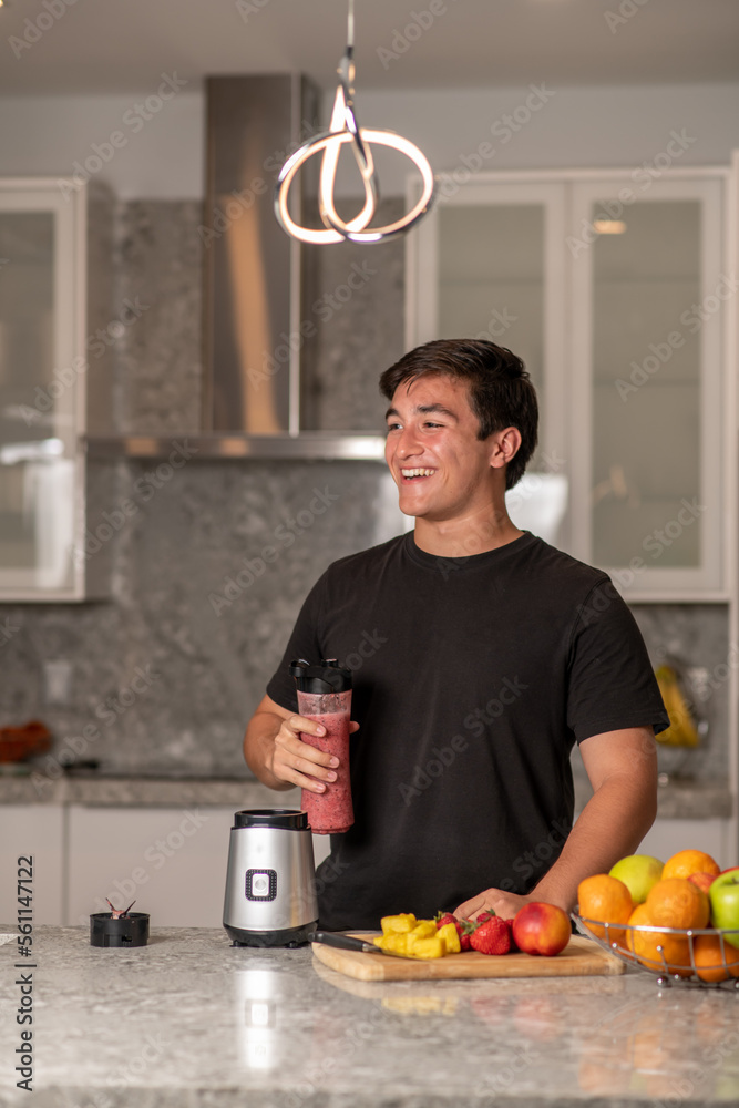 hispanic teenager preparing a smoothie on a blender
