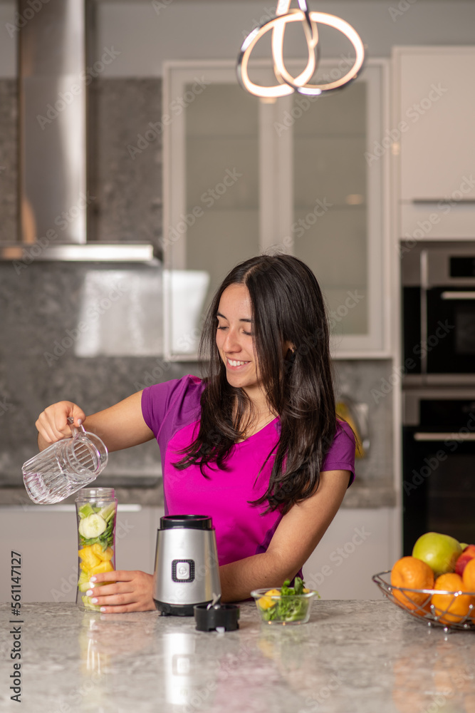 latin teen preparing a smoothie on a kitchen