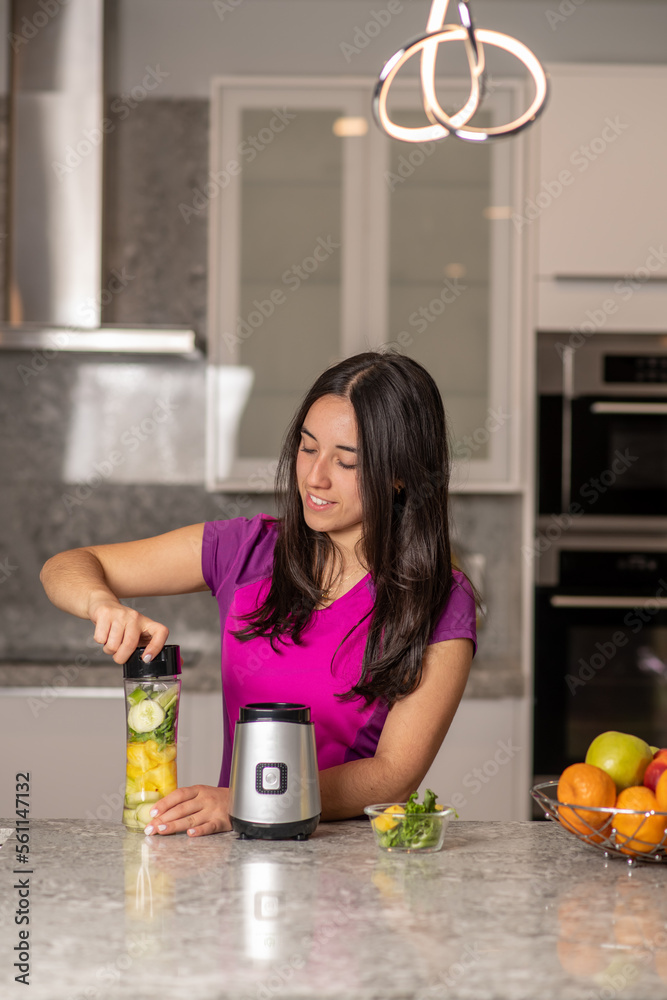 latin teen preparing a smoothie on a kitchen