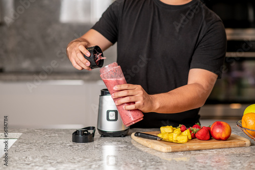 hispanic teenager preparing a smoothie on a blender