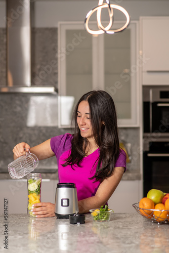 Obraz na płótnie latin teen preparing a smoothie on a kitchen w salonie