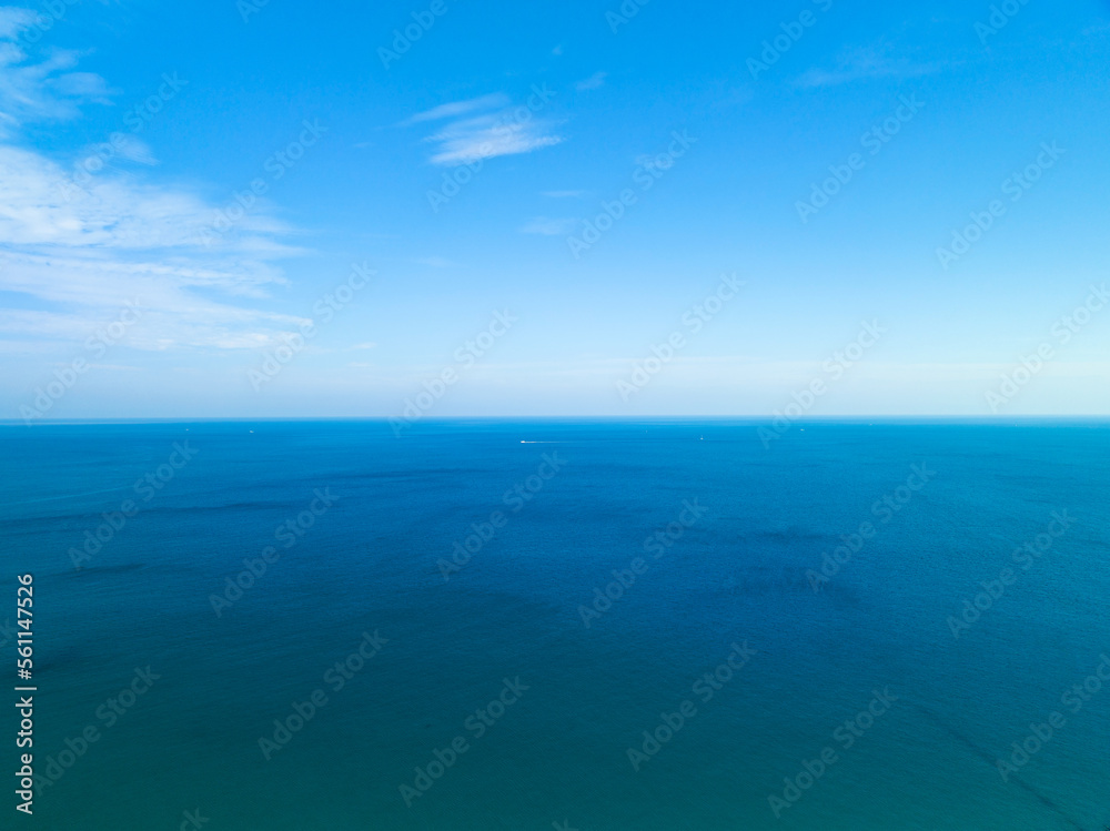 Amazing white clouds with blue sky over calm sea and sunlight reflection, Aerial view open sea ocean water surface, Sunny clear sky and clouds over ocean, Vibrant sea with clouds background