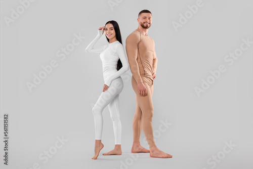 Man and woman in warm thermal underwear on light background photo