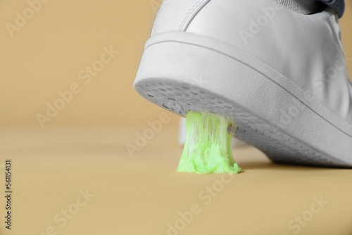 Obraz na plátně Person stepping into chewing gum on light brown background, closeup