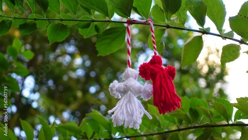 Traditional Martisor on green tree branch - symbol of 1 March, Martenitsa, Baba Marta, beginning of spring and seasons changing in Romania, Bulgaria, Moldova. Greeting and post card for holidays. photo