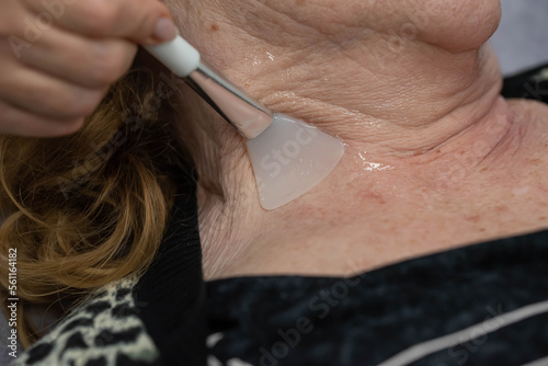 Elderly woman receiving radiofrequency lifting procedure for face skin rejuvenation and anti-age at aesthetic cosmetology center. RF lifting in beauty clinic. photo