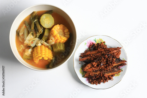 Sayur asem or sayur asam (Indonesian vegetable in tamarind soup) and Tongkol goreng bawang or fried tuna mackerel, isolated on white background.  photo