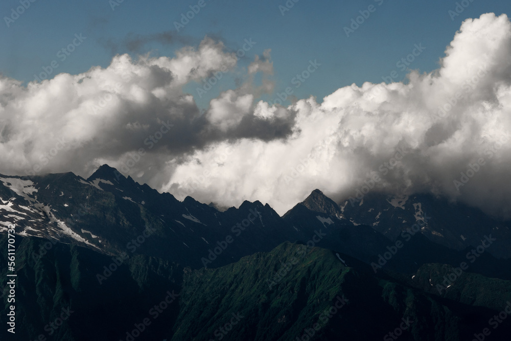 Beautiful mountain landscape, clouds over the peaks of the mountains, sunny day