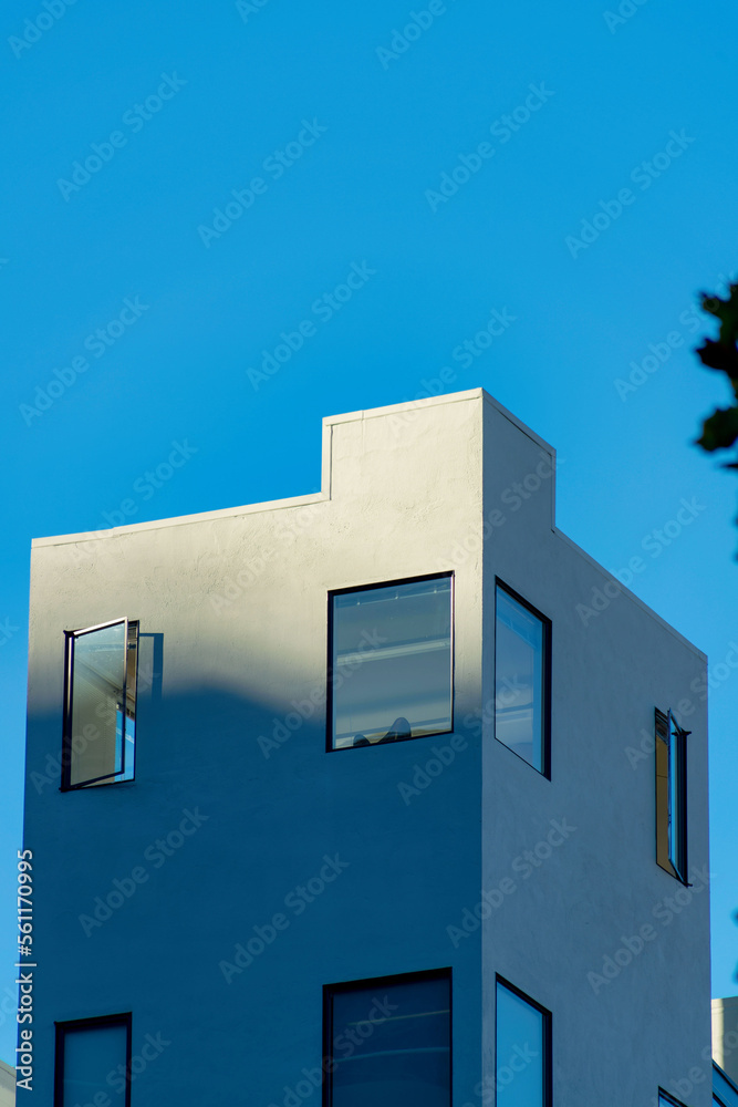 Tower or block style building with white stucco exterior and blue sky ...