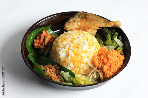 Nasi Jagung or Sego Jagung is traditional Indonesian food : rice cooked with dried corn, served with coconut vegetable salad, crunchy salted fish, and spicy sambal, isolated in white background. photo