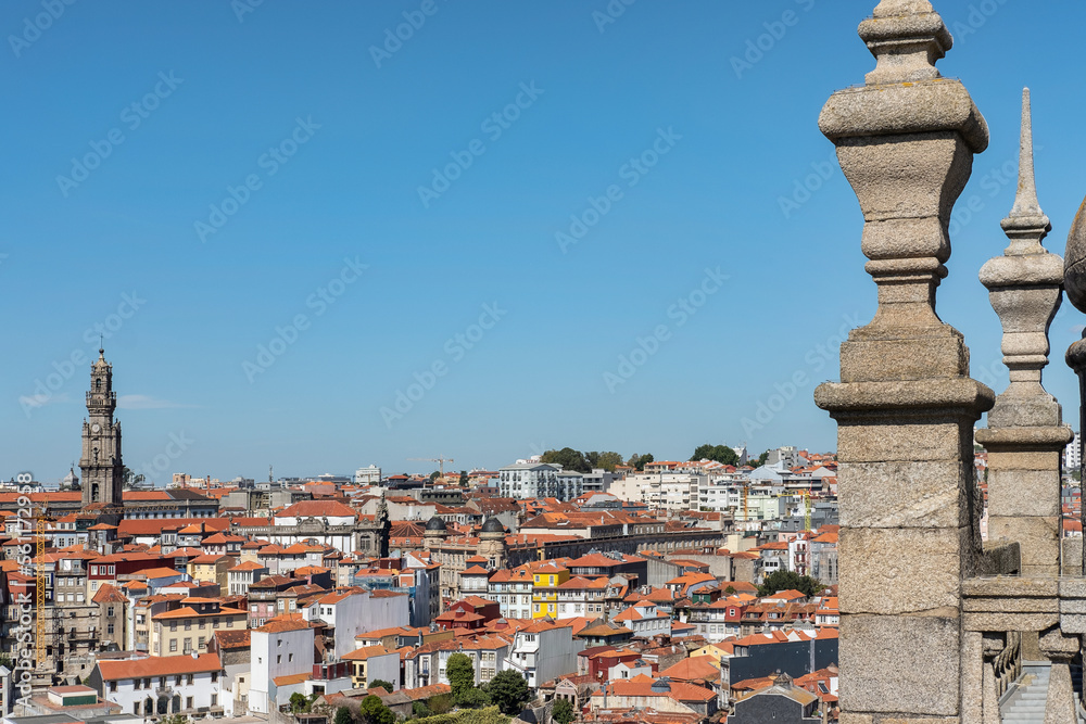 Sunny afternoon views of the traditional red rooftops covering the quaint terraced houses surrounding the cathedral hill with Clerigos Tower visible on the left, in Poro, Portugal