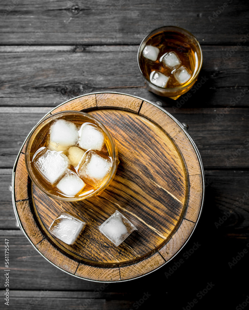 Whiskey in glasses with ice on the barrel. Whiskey in glasses with ice on the barrel.