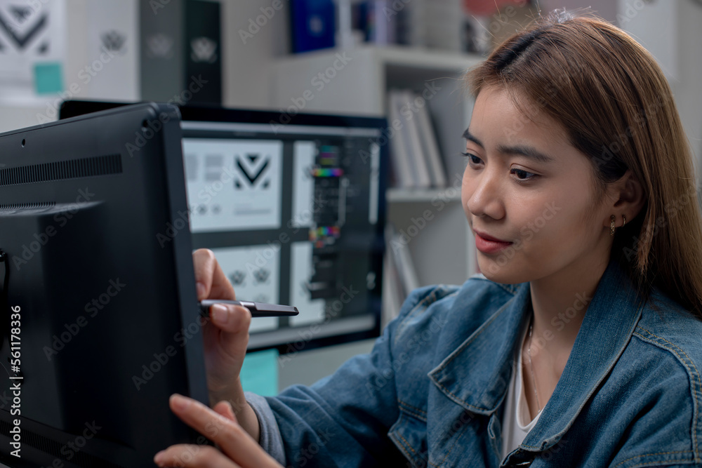 Asian female graphic designer working on computer drawing sketches logo design. The concept of a new brand. Professional creative occupation with idea.