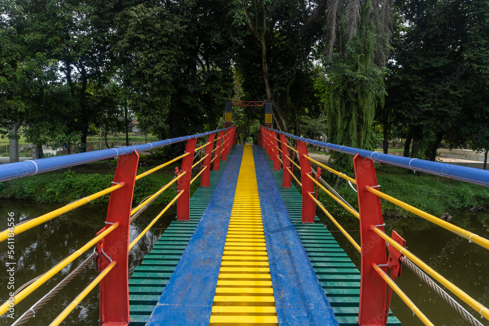 Colorful suspension bridge in the middle of a city park Colorful suspension bridge in the middle of a city park
