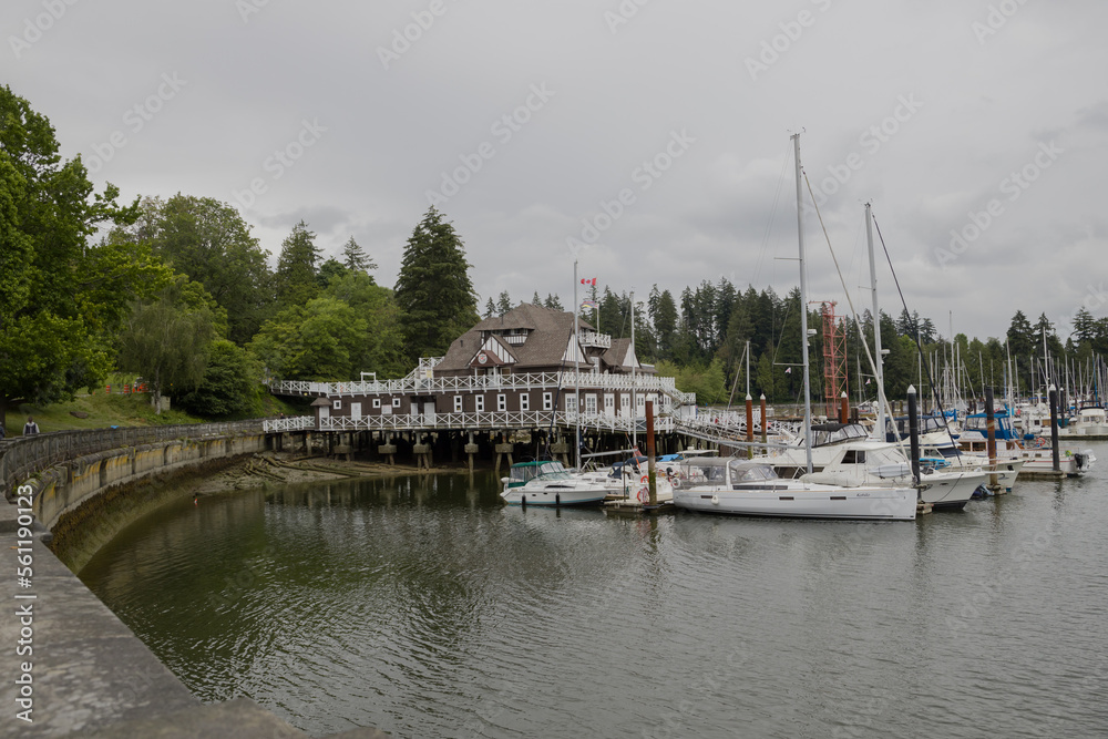 Fototapeta premium Summer trip across America - Stanley Park waterfront, downtown Vancouver, harbor with yachts and boats, skyscrapers and nature. Calm water of the bay.