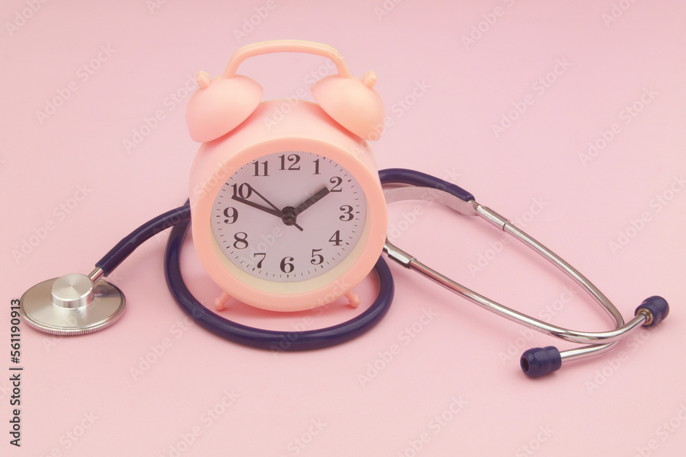 Time to visit doctor concept. Alarm clock and stethoscope on pink background. Time to visit doctor concept. Alarm clock and stethoscope on pink background.