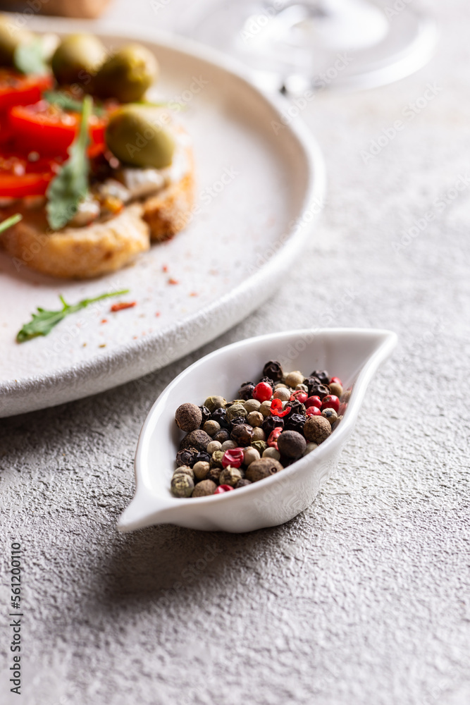 Small bowl with peppercorns on a table Small bowl with peppercorns on a table