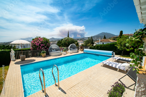 a poolside image inside a luxury chalet with Mediterranean mountain views  © josehidalgo87