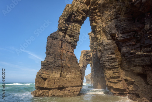 Natural stone arches of Cathedrals beach (Playa de las Catedrales) or Praia de Augas Santas, amazing landscape with rocks in the ocean and blue sky, Ribadeo, Galicia, Spain. Outdoor travel background photo