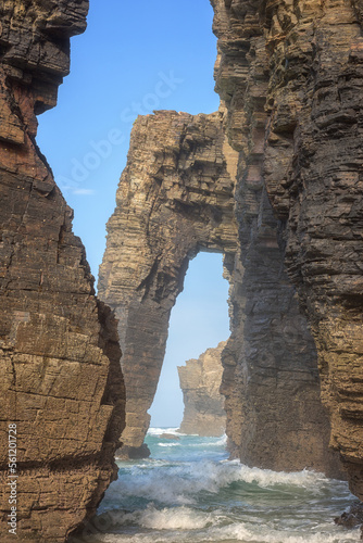 Natural stone arches of Cathedrals beach (Playa de las Catedrales) or Praia de Augas Santas, amazing landscape with rocks in the ocean and blue sky, Ribadeo, Galicia, Spain. Outdoor travel background photo