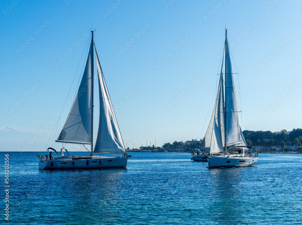 Fototapeta premium sailing yacht boats with white sails in blue sea , seascape of beautiful ships in sea gulf with mountain coast on background